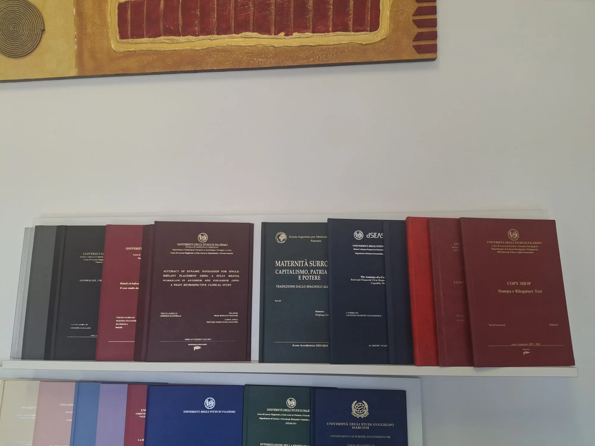 Lo scaffale della copisteria con le tesi di laurea rilegate pronte per il ritiro