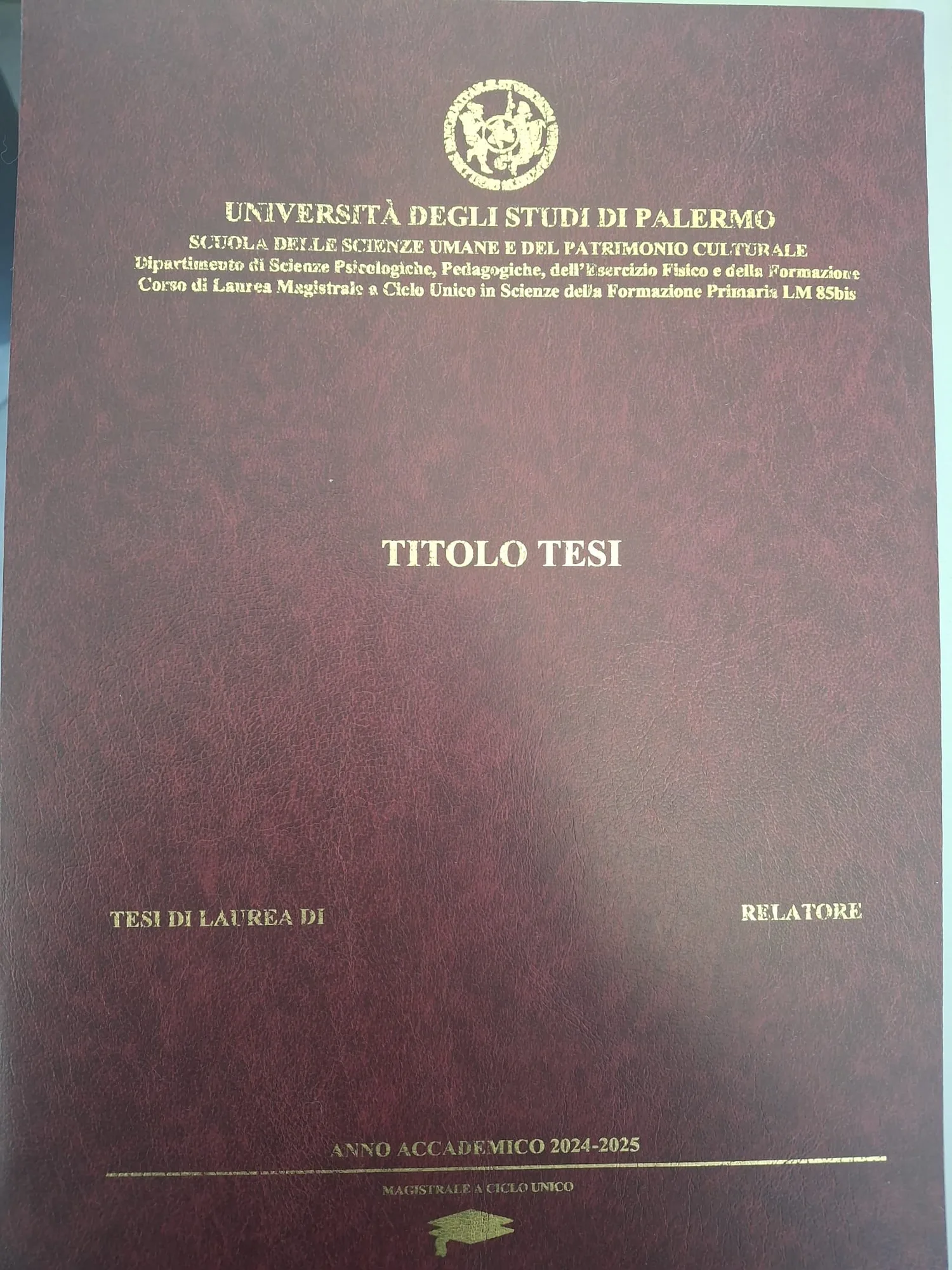 Copertina di una tesi di laurea rilegata in pelle bordeaux con titolo e stemma dell'Università degli Studi di Palermo impressi in oro