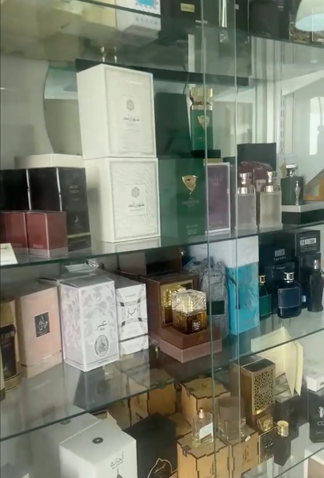 La vetrina dei profumi del salone: ripiani in vetro con flaconi e confezioni di profumi di alta gamma
